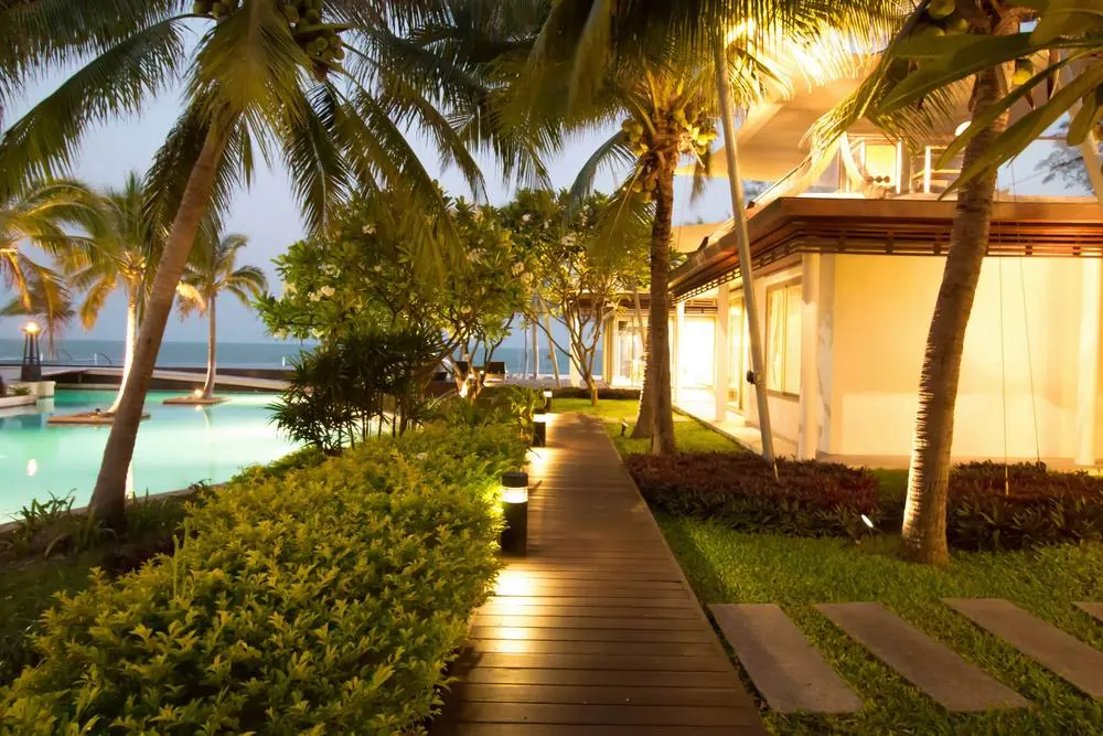 The lit timber walkway between the pavilions at dusk